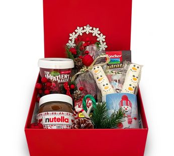 Merry christmas gift hamper with cake mix, nutella, christmas candy in a red gift box