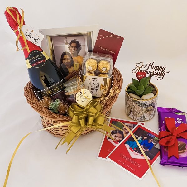 Beautiful anniversary gift basket for her adorned with grape juice, chocolates, & more