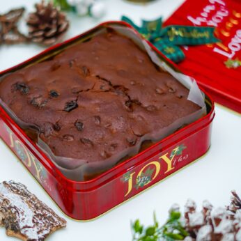 Indulge in Festive Delight with Our Christmas Cake in a Charming Red Metal Box